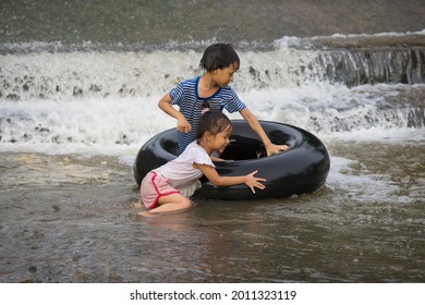 A Kids Play And Lying On A Tire Floating In Water Filmed In Chiang Mai, Thailand.