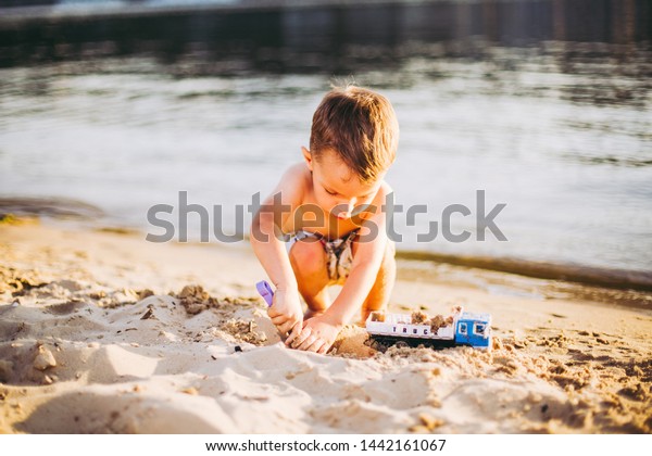 Kids Play On\
Beach. Sand And Water Toy. Truck toy car with sand and soil. green\
environment construction equipment at work ,construction concept.\
industrail symbols.