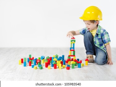 Kids Play Room, Child in Hard Hat Playing Building Blocks Toys. Development and Construction Concept