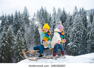 Kids play snowball, snow ball fight for children. Christmas winter holidays and happy New Year for kids. Winter children fashion clothes. Winter fun kids activities.