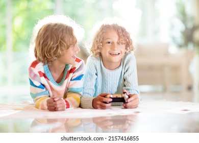 Kids Play Video Game. Children With Remote Controller. Boy In Sunny Living Room Playing On The Floor. Gaming Device. Indoor Activity For School Child. Safe Internet. Brothers Having Fun.