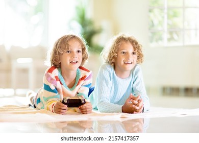 Kids Play Video Game. Children With Remote Controller. Boy In Sunny Living Room Playing On The Floor. Gaming Device. Indoor Activity For School Child. Safe Internet. Brothers Having Fun.