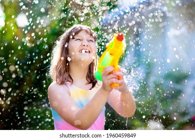 Kids Play With Water Gun Toy In Garden. Outdoor Summer Fun. Little Boy Playing With Water Hose In Sunny Backyard. Party Game For Children. Healthy Activity For Hot Sunny Day.