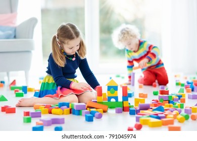 Kids Play With Wooden Toy Blocks. Educational Colorful Toys For Children. Boy And Girl Playing In Kindergarten Room With Big Window. Kid Building Tower With Rainbow Blocks. Child At Home