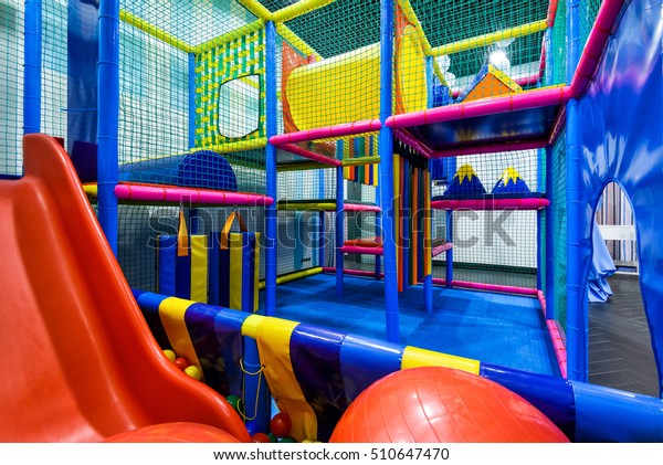 Kids playground indoor, inside plastic jungle\
for playing and development of motor skills. Children\'s gym with\
slide and maze in kindergarten indoor. Modern soft playground in\
playroom.