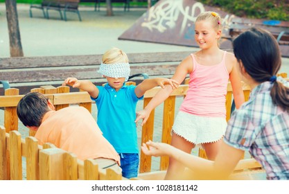 Kids are playing in blindfolders on the playground.