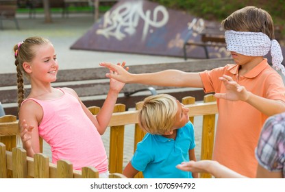 Kids are playing in blindfolders on the playground.