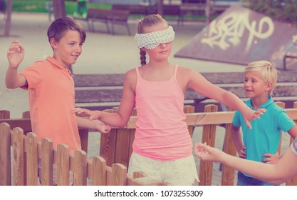 Kids are playing in blindfolders on the playground.