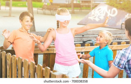 Kids are playing in blindfolders on the playground.