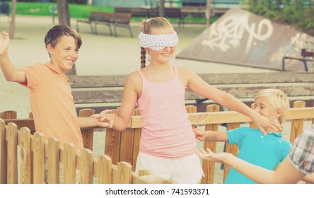 Kids are playing in blindfolders on the playground.