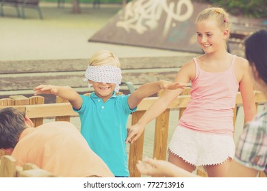Kids are playing in blindfolders on the playground.