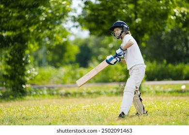 Kids playing cricket in summer park. Boy with bat and ball on cricket pitch. Helmet and guard for safe game. Sport for active child. Cricket club for school children. Sports activity and exercise. - Powered by Shutterstock