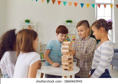 Kids Playing With Educational Toys In After School Club. Group Of Happy Diverse 8-10-year-old Children Are Busy With Wood Block Tower Stacking Board Game During Birthday Party At Home