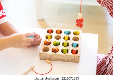 Kids Are Playing And Finding The Matched Number In The Wooden Magnetic Fishing Game, Using Wooden Fishing Pole Provided With Magnets To Attach The Mouth Of The Fish And Picking It Up.