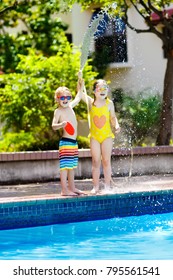 Kids Playing With Garden Hose In Backyard With Large Outdoor Swimming Pool. Children Play With Water. Swim Wear And Toys For Boy And Girl. Family Summer Vacation With Hot Sunny Weather. Garden Pool.