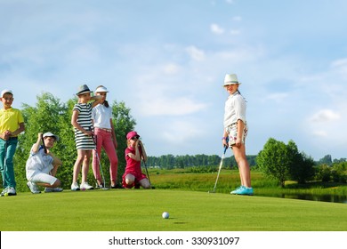 Kids Playing Golf By Putter On Green