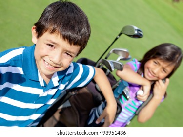 Kids playing golf and holding a bag at the course