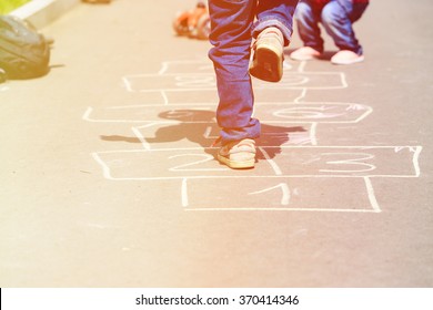 Kids Playing Hopscotch On Playground Outdoors