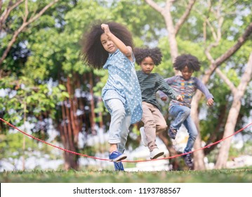 Kids Playing Jump Over The Rope In The Park On Sunny Summer Day