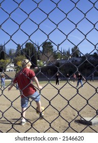 Kids Playing Kickball At A School.