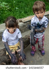 Kids Playing In Mud. Dirty Clothes And Hands. Stains On Clothes