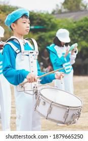 Kids Playing Music In Marching Band, Cute Asian Child Hitting Drum Instrument On Sport Day In School