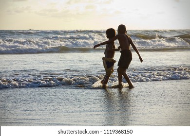 Kids playing near the sea waves