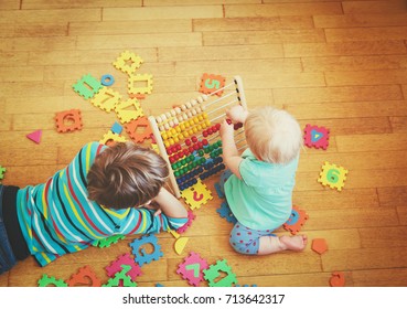 Kids Playing With Number Puzzle And Abacus