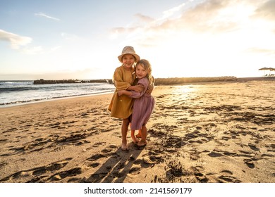 Kids Playing On The Beach. Little Sisters Having Fun At Sea Shore At Sunset. Family Summer Vacation Vibes. A Lot Of Copy Space.
