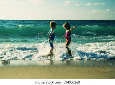 Kids Playing On The Beach At Sunset