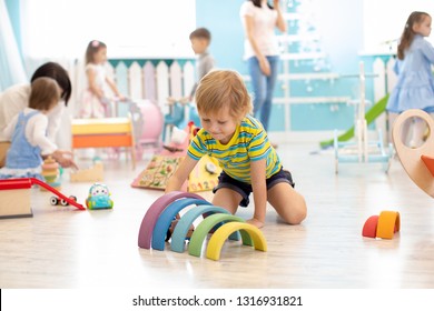 Kids Playing On Floor With Educational Toys. Toys For Preschool And Kindergarten. Children In Nursery Or Daycare