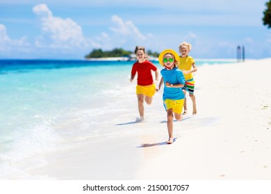 Kids Playing On Tropical Beach. Children Swim And Play At Sea On Summer Family Vacation. Sand And Water Fun, Sun Protection. Little Child Running And Jumping At Ocean Shore.