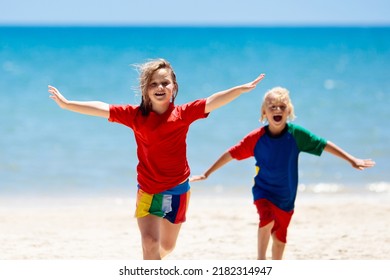 Kids Playing On Tropical Beach. Children Swim And Play At Sea On Summer Family Vacation. Sand And Water Fun, Sun Protection For Young Child. Little Boy And Girl Running And Jumping At Ocean Shore.