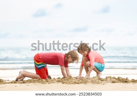 Similar – Two kids digging on the beach