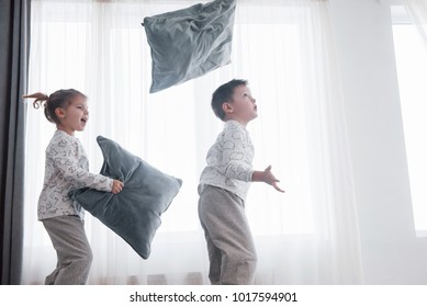 Kids Playing In Parents Bed. Boy And Girl In Matching Pajamas. Sleepwear And Bedding For Child, Family Morning.