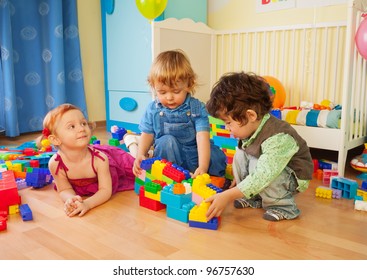 Kids Playing With Plastic Blocks - Two Boys And Girl