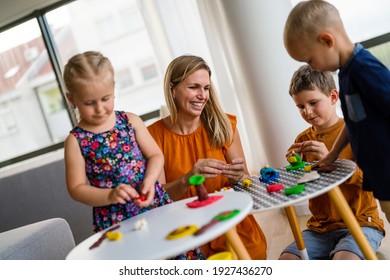 Kids playing with plasticine. Teacher or mother play with children. People, kid creativity concept - Shutterstock ID 1927436270