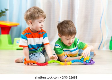 Kids Playing Rail Road Toy In Nursery