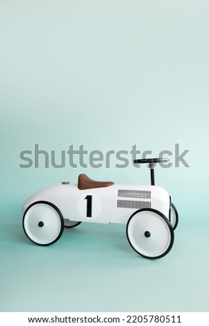 Kid's playing room interior. Retro style beige toy car on blue background. Stylish toy for toddler boy. Copyspace.