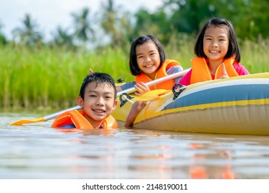 Kids playing and rowing boat in river on summer holiday season, children wearing life jacket for safety, happy child joyful and funny for play activity outdoors, relaxing time for people on hot season - Powered by Shutterstock