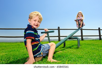 Kids playing at the see-saw in the playground - Powered by Shutterstock