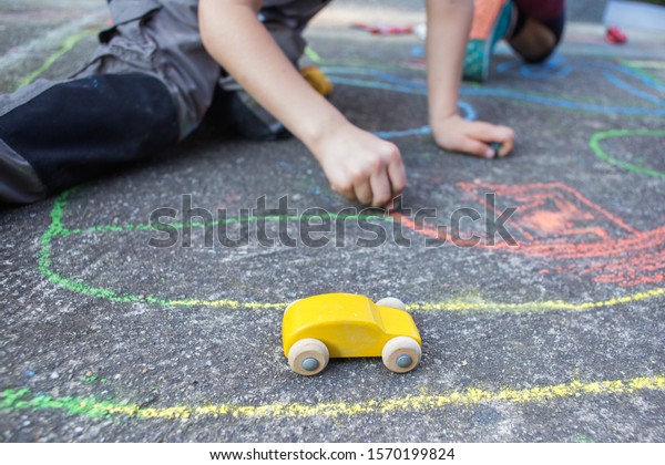 kids\
playing with small car toys on the\
playground