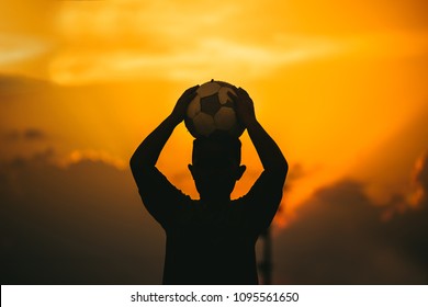 Kids Are Playing Soccer Football For Exercise Under The Sunlight. Silhouette And Film Picture Style.