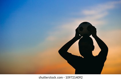 Kids Are Playing Soccer Football For Exercise Under The Sunlight. Silhouette And Film Picture Style.