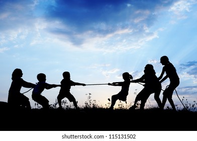 Kids playing tug war pulling rope - Powered by Shutterstock