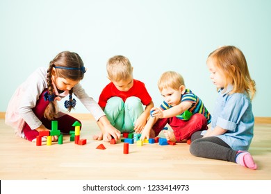 Kids Playing With Wooden Blocks At Kindergarten