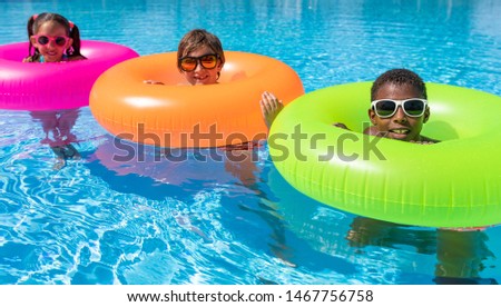 kids in the pool happy and smiling on a sunny day