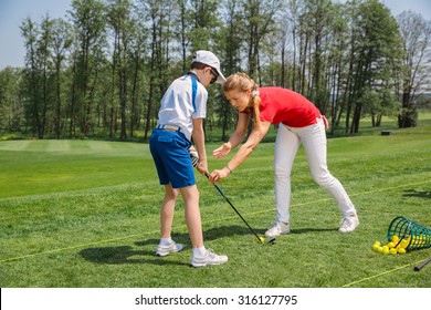 Kids practicing with trainer at golf school at summer day