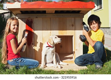 Kids Preparing A Shelter For Their New Puppy Dog - Finishing And Painting The Doghouse