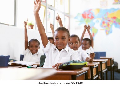 Kids raising hands during a lesson at an elementary school